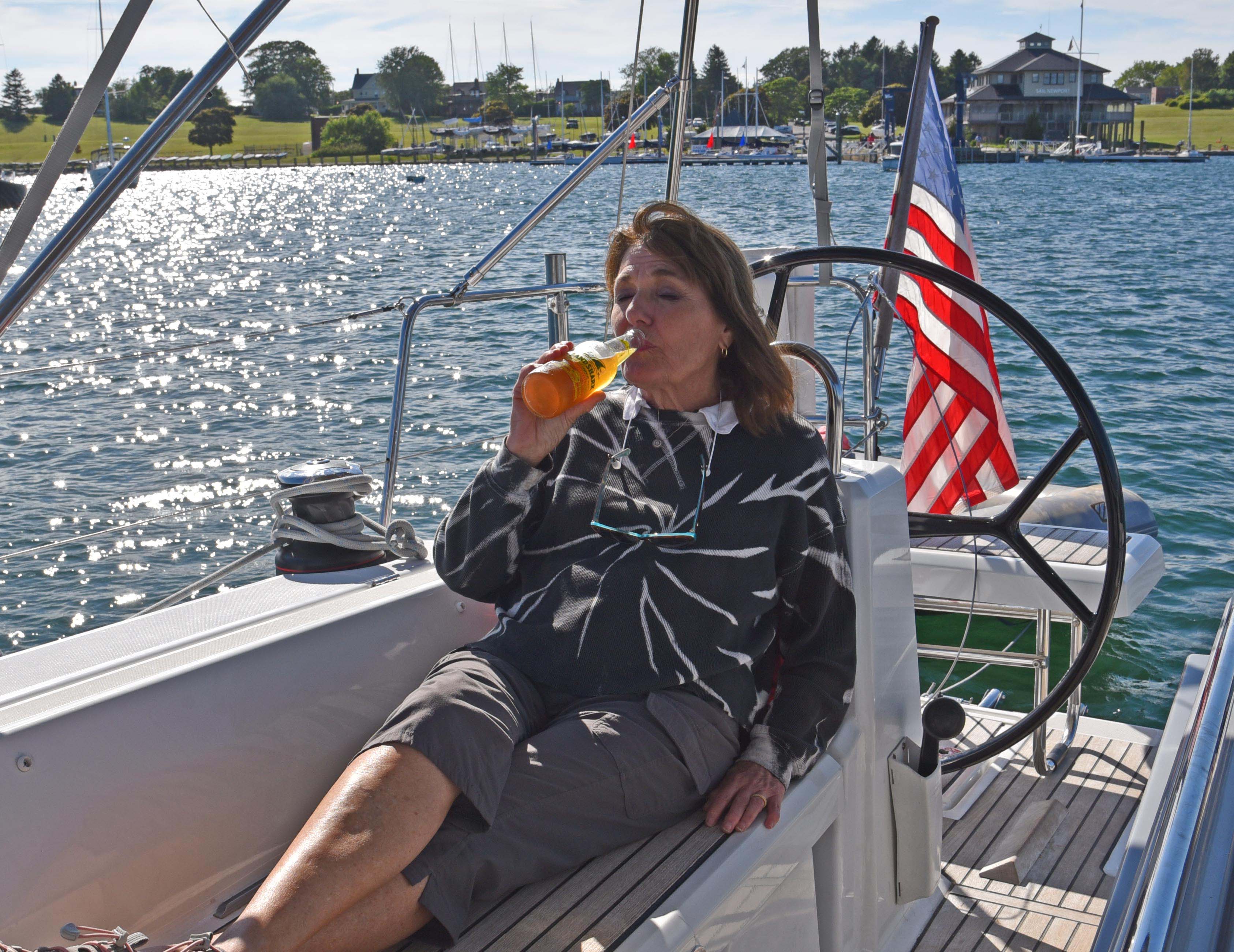 Woman with beer in cockpit at end of day